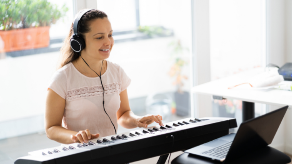 A person wearing headphones and playing a keyboard
